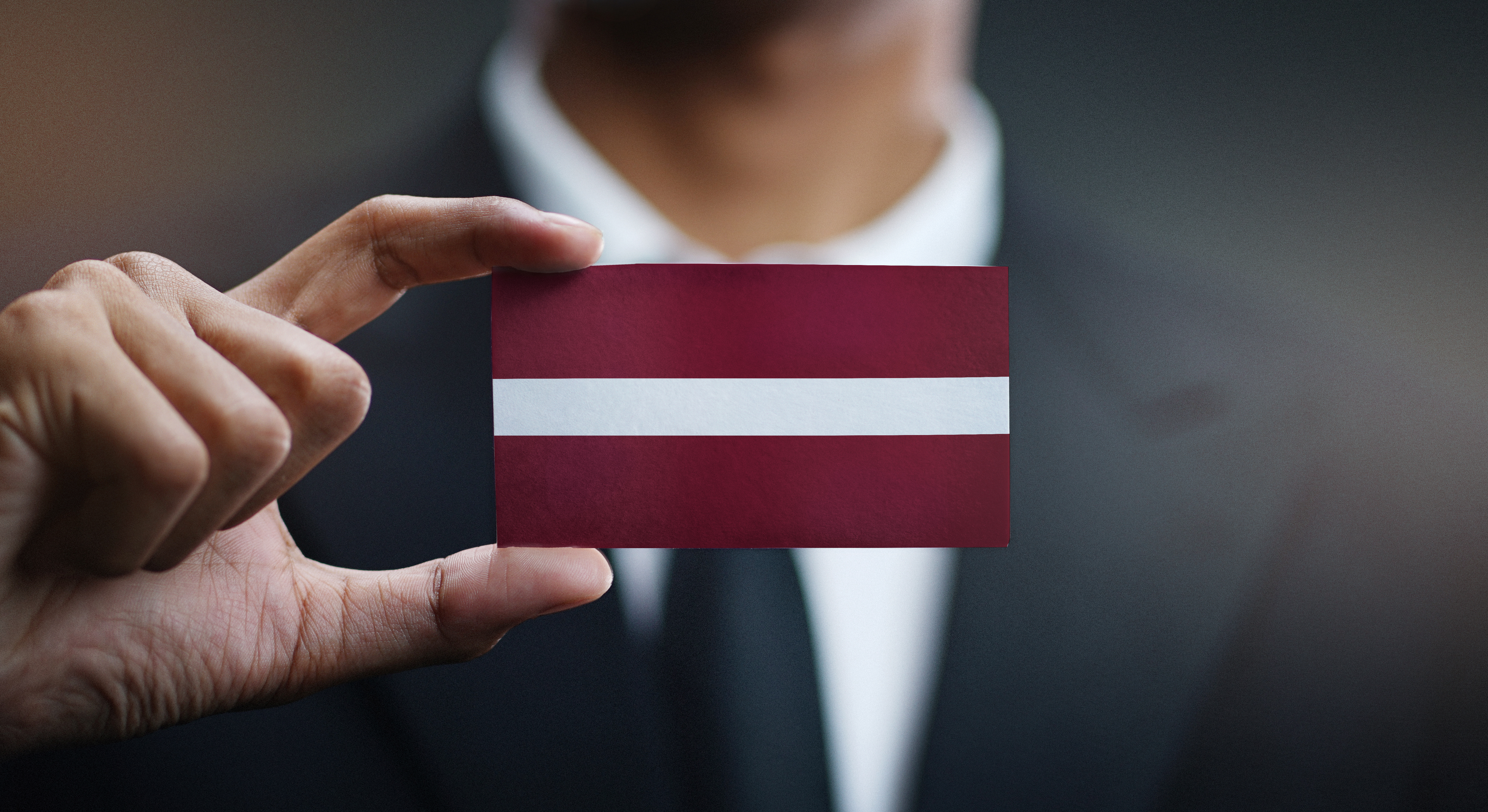 Бизнесмен с флагом Латвии, где иностранцы могут открыть бизнес