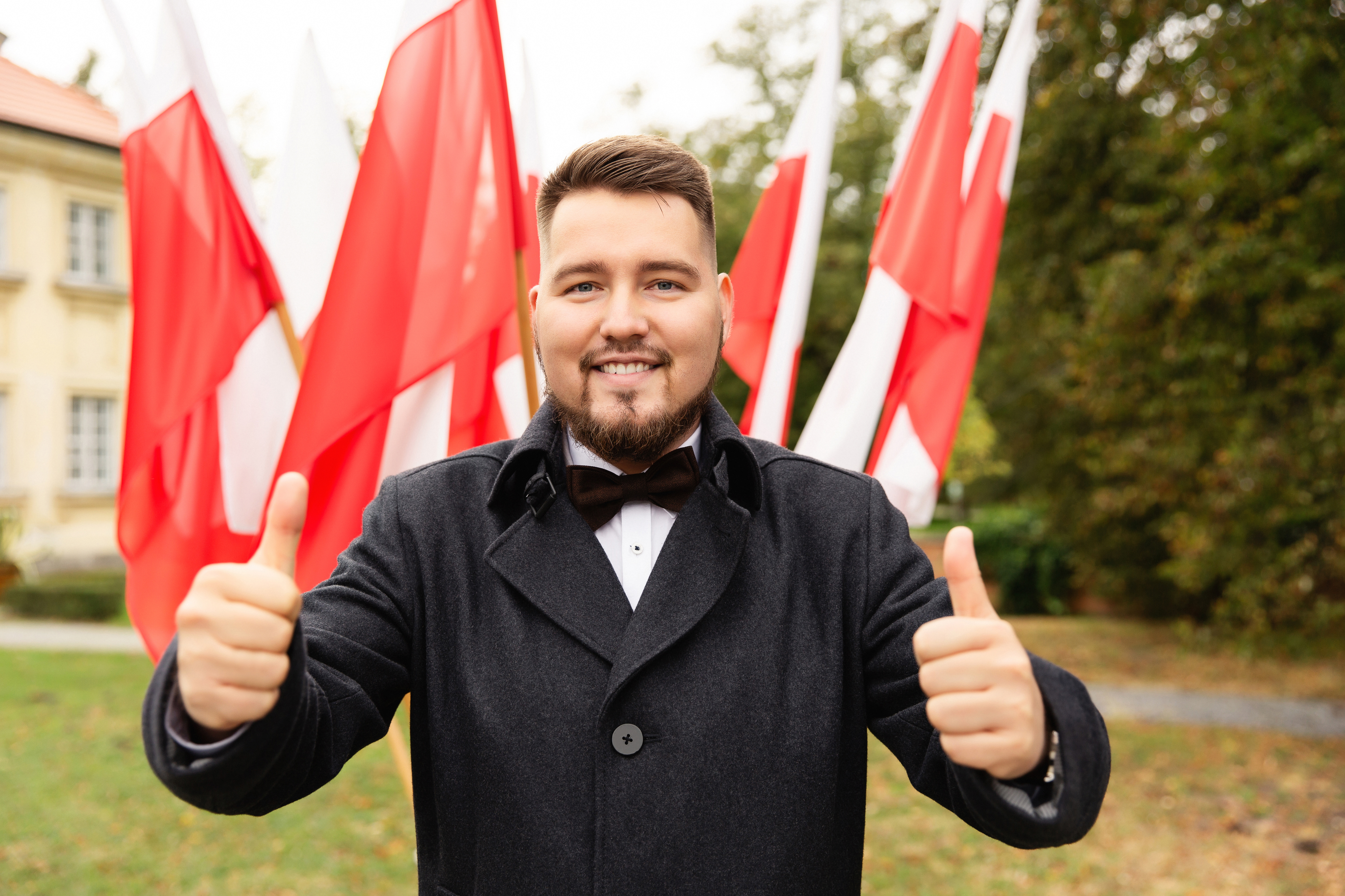 Парень на фоне флагов Польши, куда могут иммигрировать иностранцы