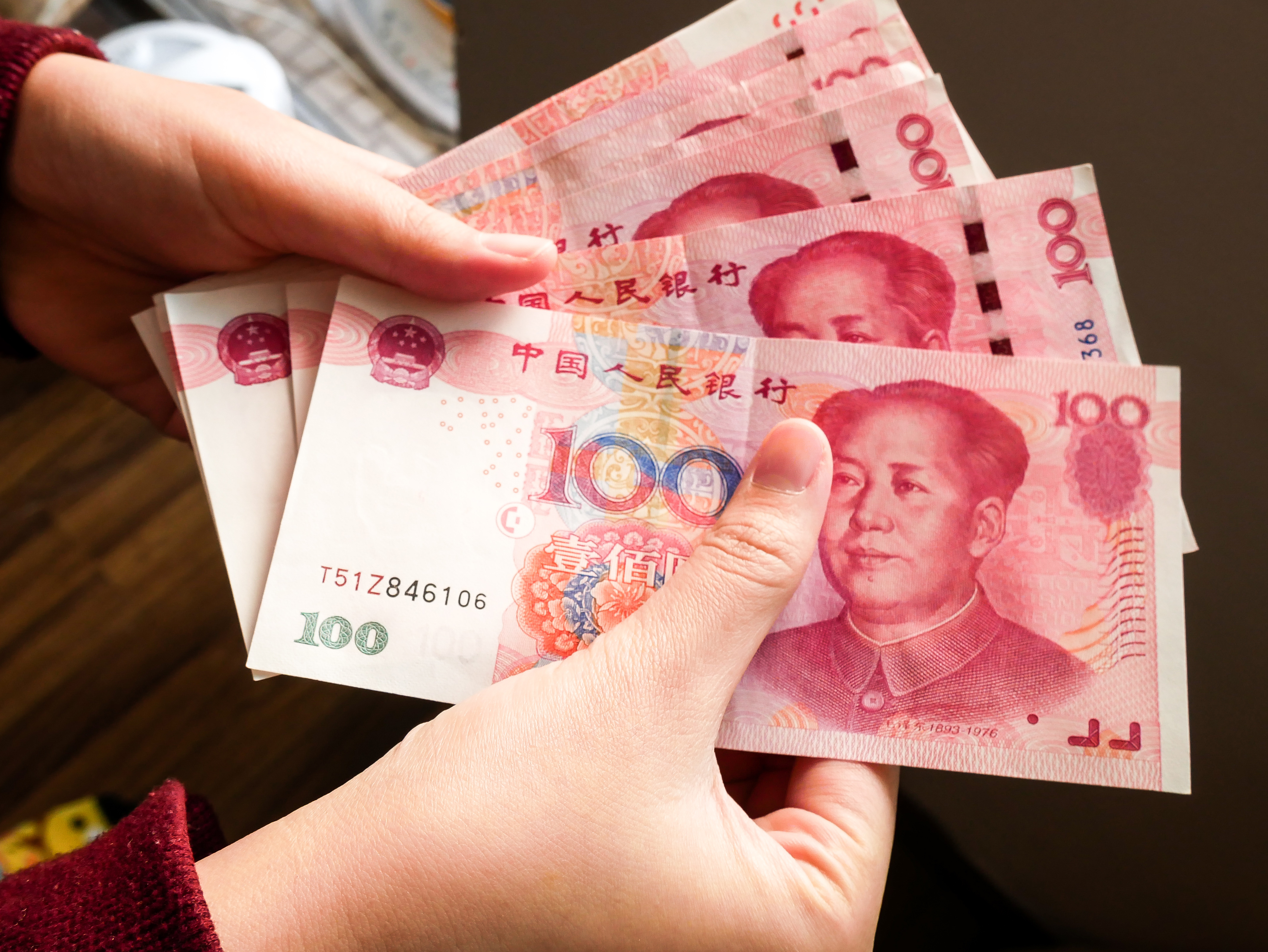 Китайские юани в руках - прототип средней зарплаты в Китае