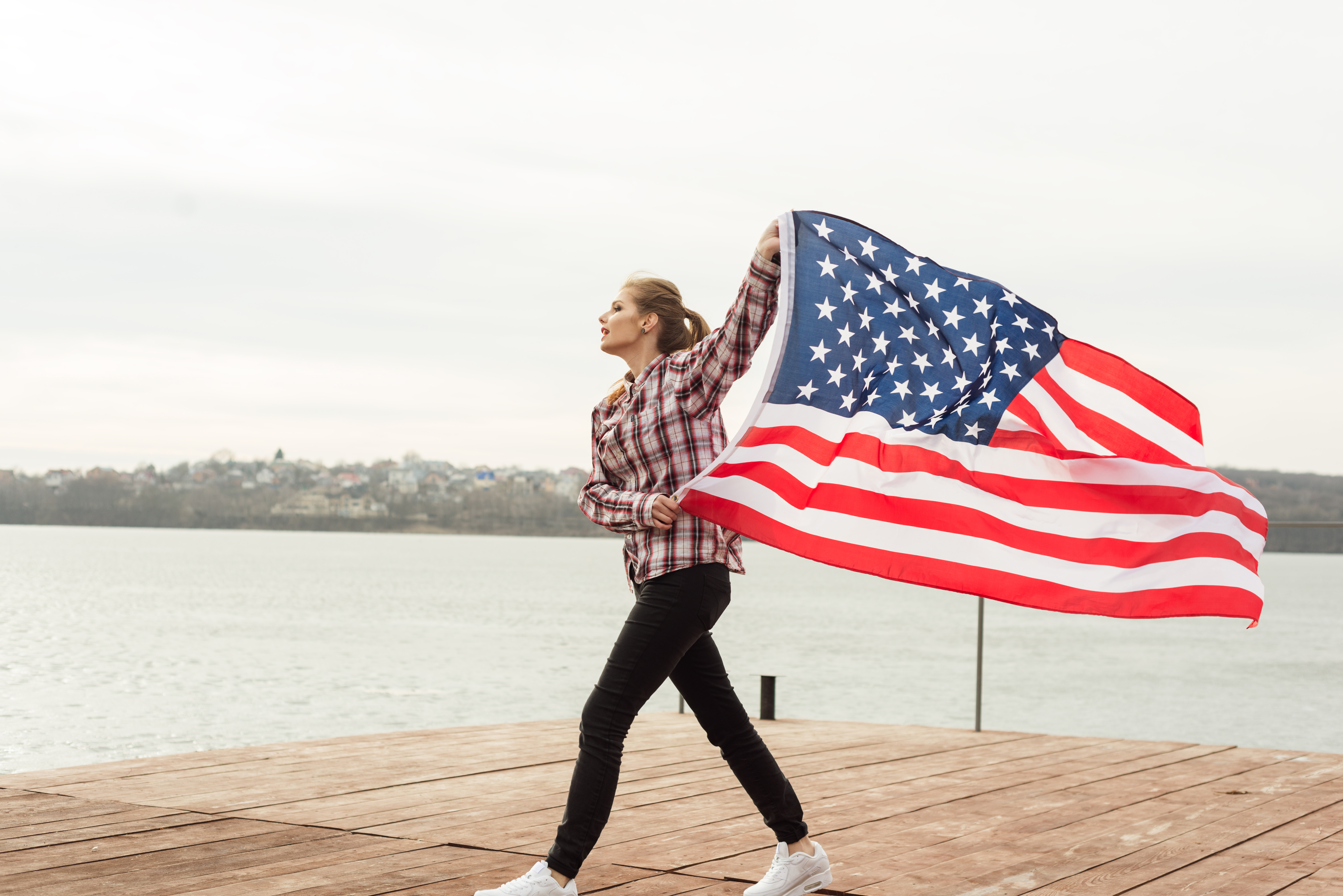 Девушка с флагом США, где возможна легализация пребывания для иностранцев