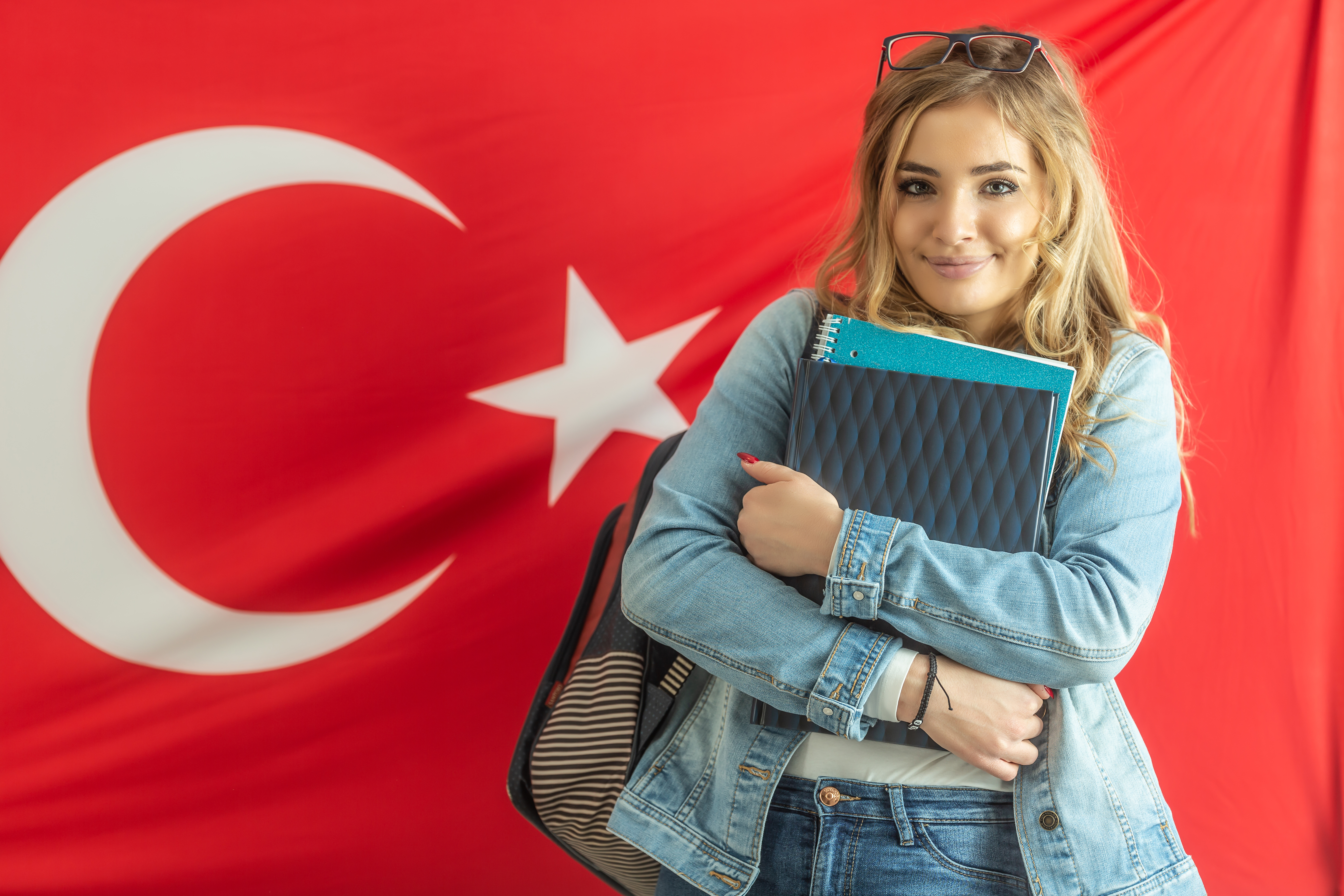 Студентка на фоне флага Турции, куда могут уехать на учебу иностранцы