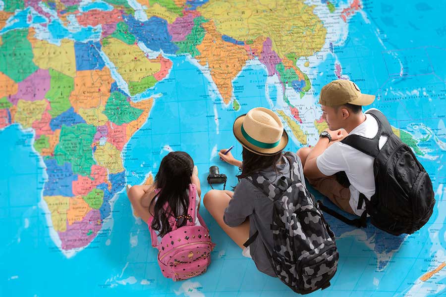Семья смотрит на карту мира и решает, куда переехать на ПМЖ