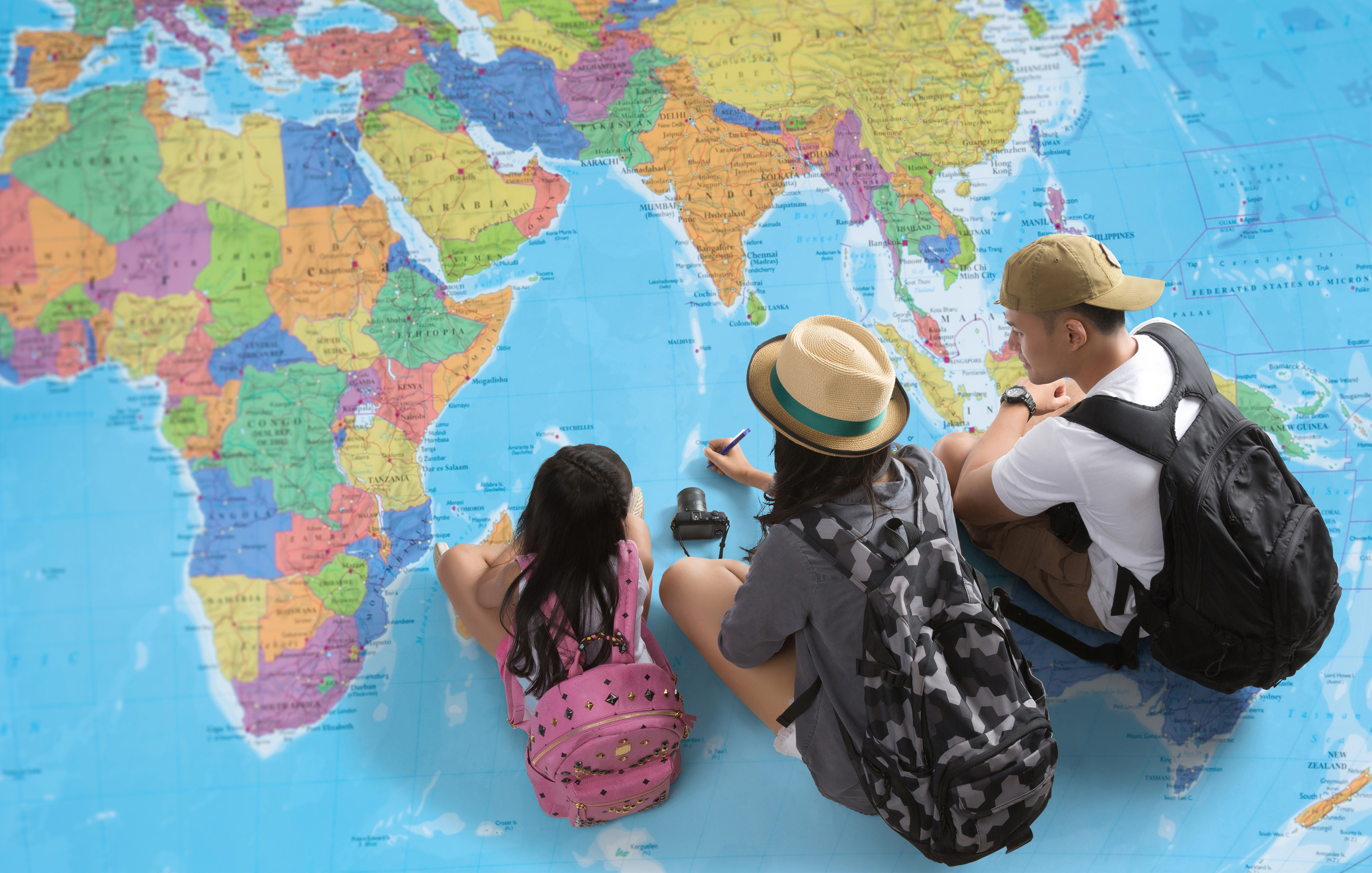 Семья смотрит на карту мира и решает, куда переехать на ПМЖ