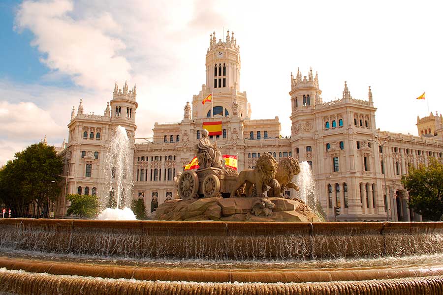 Испанские флаги возле фонтана Сибелес в Испании, ПМЖ которой могут получить иностранцы