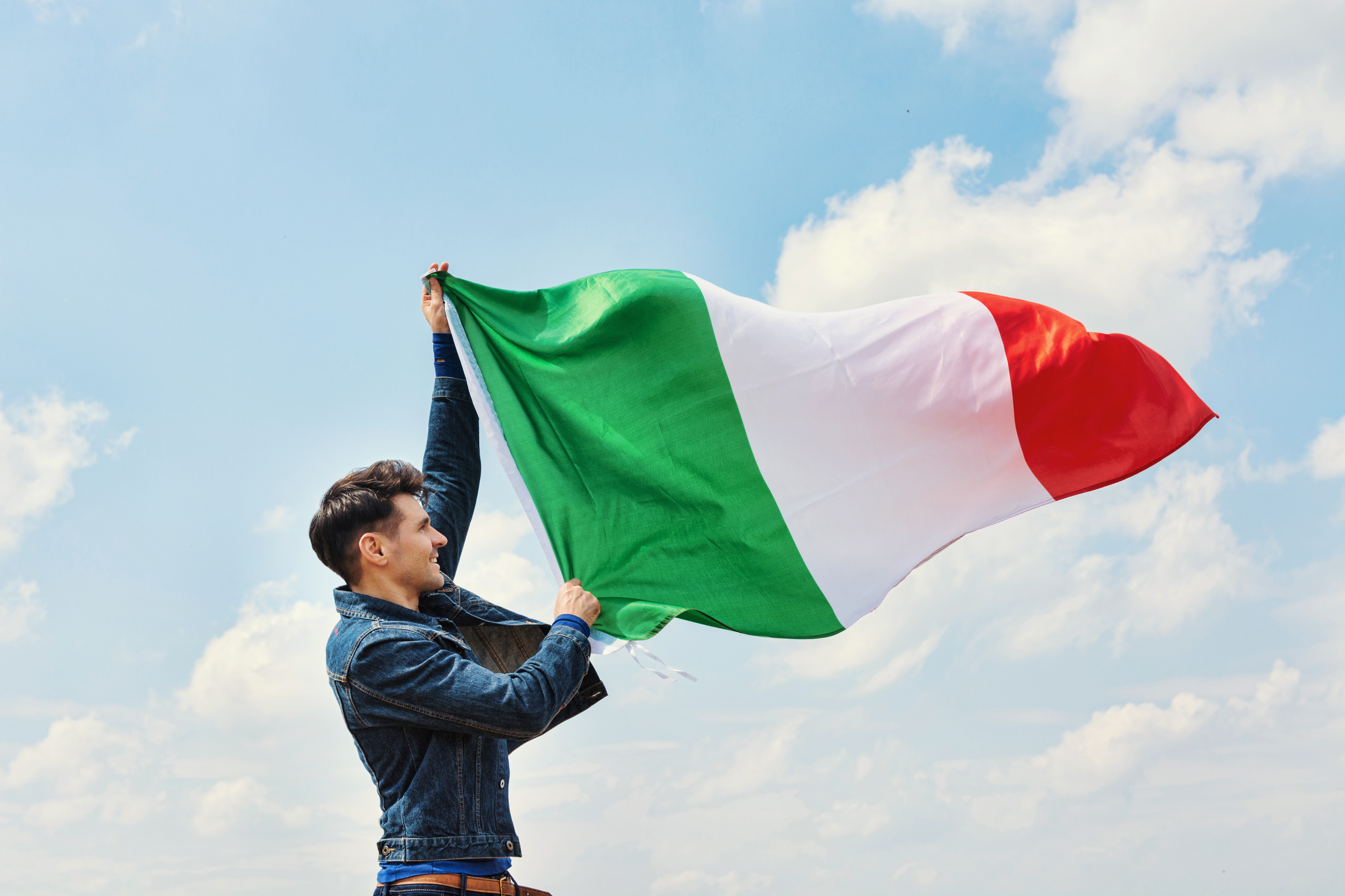 Парень с флагом Италии, ВНЖ которой можно получить по работе
